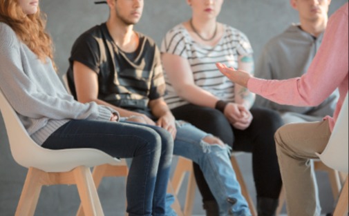 group of youth sitting in a circle talking