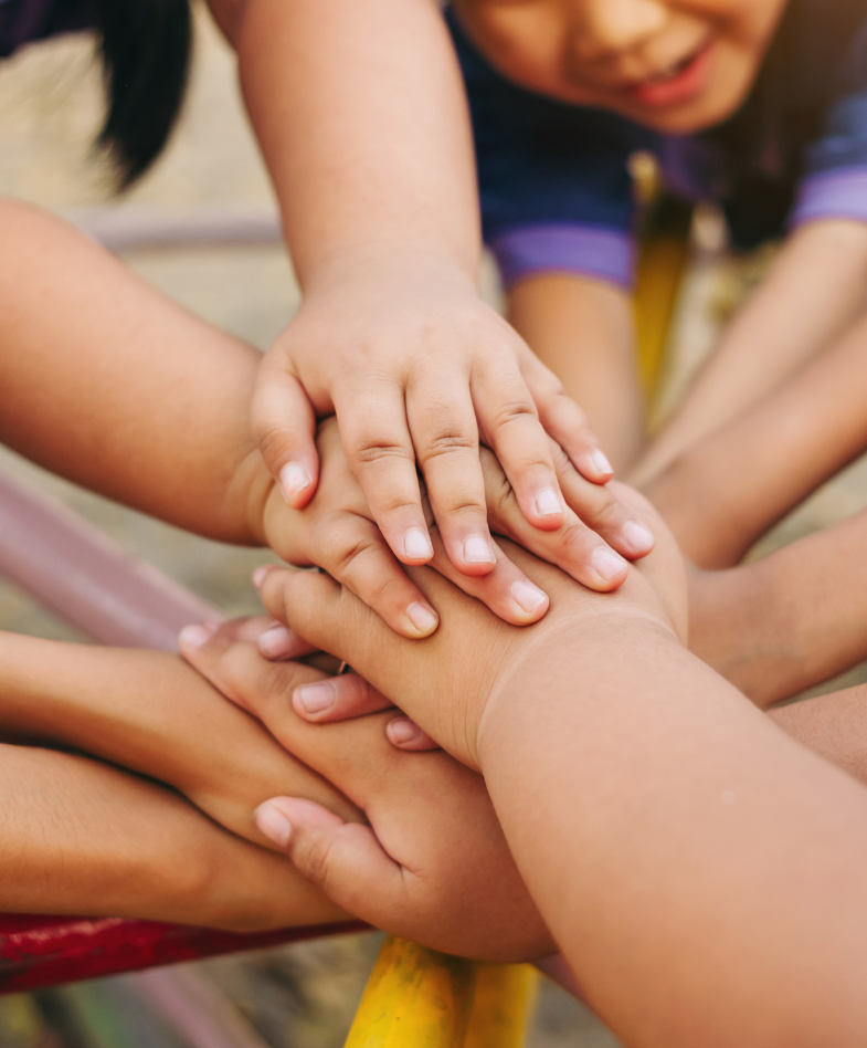 kids with their hands in the centre of a circle